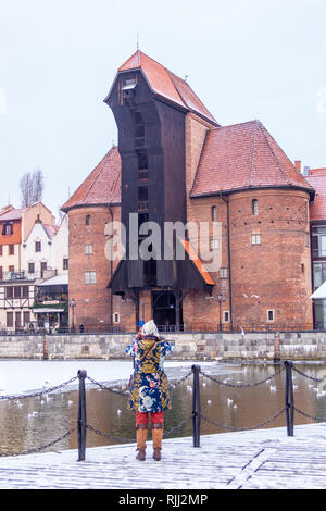 Eine Frau in einer bunten Mantel fotografieren Mottlau Waterfront und Kran, Zuraw, rybackie Pobrzeże, Danzig, Polen Stockfoto