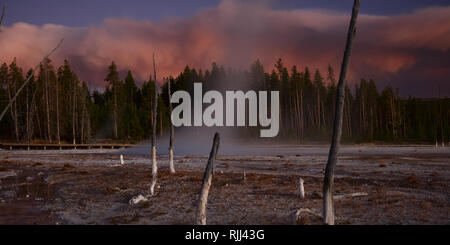 Dampf steigt von Celestine Geysir vor dem Hintergrund der Sonne - getönte Rauch aus der Arnika Feuer im Yellowstone National Park. Stockfoto