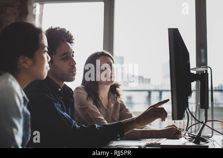 Mitarbeiter, die an einen Desktop-PC zusammen Stockfoto