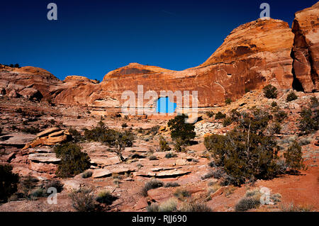 Januar 2019: Alte Canyon Wände und tiefen Winter blauer Himmel Rahmen der spektakulären Gold Bar Arch, auch als Jeep Arch, in der Nähe von Canyonlands NP bekannt. Stockfoto