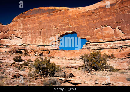 Januar 2019: Alte Canyon Wände und tiefen Winter blauer Himmel Rahmen der spektakulären Gold Bar Arch, auch als Jeep Arch, in der Nähe von Canyonlands NP bekannt. Stockfoto