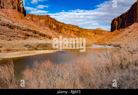 Januar 2019: Der Colorado River schlängelt sich entlang der Utah Highway 128 und bietet eine reizvolle Fahrt in den roten Sandstein Canyons in der Nähe von Moab, Utah. Stockfoto