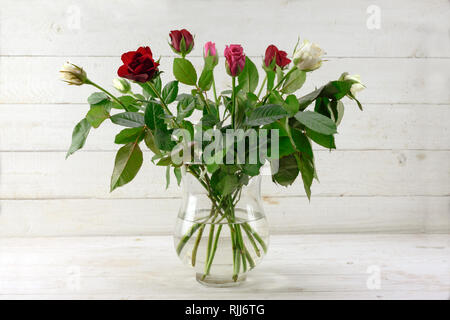 Blumenstrauß mit Rosen in Rot, Rosa, Weiß und in ein Glas Vase auf hellgrau lackiert rustikal Holz, Kopie, ausgewählte konzentrieren Stockfoto