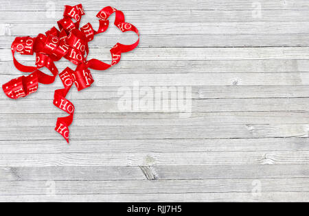 Curly red christmas Band auf Grau rustikal im Alter von Holz Stockfoto