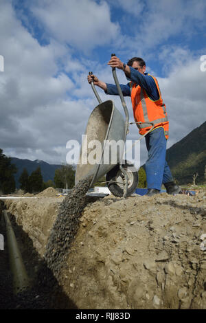 Ein Handwerker Tipps Kies in einen neuen Abfluss von Regenwasser Stockfoto