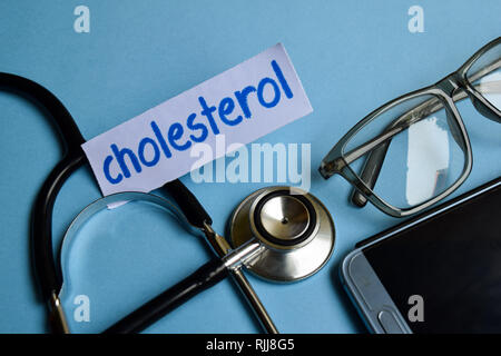 Konzeptionelle Bild mit Cholesterin Inschrift mit der Ansicht von Stethoskop, Brillen und Smartphone auf dem blauen Hintergrund. Medizinische konzeptionell. Stockfoto