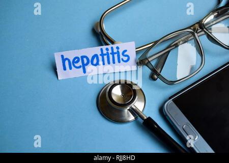 Konzeptionelle Bild mit Hepatitis Inschrift mit der Ansicht von Stethoskop, Brillen und Smartphone auf dem blauen Hintergrund. Medizinische konzeptionell. Stockfoto