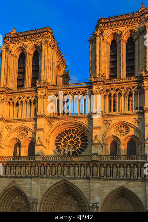 Details von der Hauptfassade der Kathedrale Notre Dame de Paris Fassade mit dem ältesten Rosette und kunstvollen Maßwerk im warmen Licht der untergehenden Sonne Stockfoto