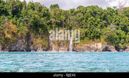 Ein Foto im Querformat auf einen schönen Wasserfall über einer Klippe an der tropischen Küste von Corcovado National Park, Costa Rica. Stockfoto