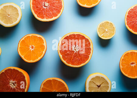 In der hälfte saftige Zitrusfrüchte auf einem blauen Hintergrund Stockfoto