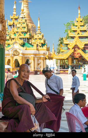 Ein birmanischen buddhistischen Mönch ruht auf den Stufen Shwedagon Pagode Tempel Komplex in Yangon, Myanmar. Stockfoto