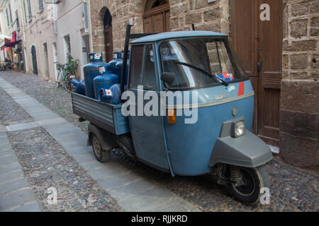 Kleinen dreirädrigen Auto Transport von Gasflaschen in der Altstadt von Alghero, Sardin, Italien Stockfoto