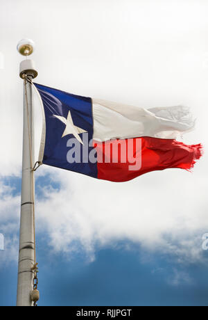 Ein tattered Texas State Flag Wellen auf den Mast gegen den Himmel Stockfoto