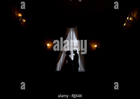 Gerne luxus Braut und Bräutigam stehen am Fenster Licht in den Reichen Zimmer, bewegender Moment Stockfoto