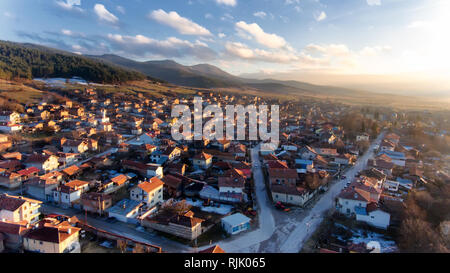 Antenne drone Foto - Die schönen kleinen Dorf Dorkovo in bulgarischen Berge, Sonnenuntergang Winter Stockfoto