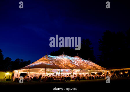 Hochzeit Zelt bei Nacht - Special Event Zelt von innen beleuchtet mit dunkelblauen Nacht Himmel und Bäume Stockfoto