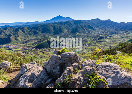 Den Blick über das Tal von El Palmar und einen Hügel gegraben aus für den Mutterboden, mit Teide in der Ferne, Teno, Teneriffa, Kanarische Inseln, Spanien Stockfoto