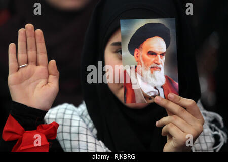 06. Februar 2019, im Libanon, in Beirut: ein Anhänger der Hisbollah, die pro-iranischen Libanesische Islamistische politische Partei und militanten Gruppe, hält ein Bild von Ayatollah Khomeini, ehemaliger Oberster Führer des Iran und Führer der iranischen Revolution von 1979, während einer Kundgebung zum 40. Jahrestag der Islamischen Revolution des Iran, Mohammad Reza Pahlavi, der letzte Schah von Iran gestürzt zu markieren. Foto: Marwan Naamani/dpa Stockfoto