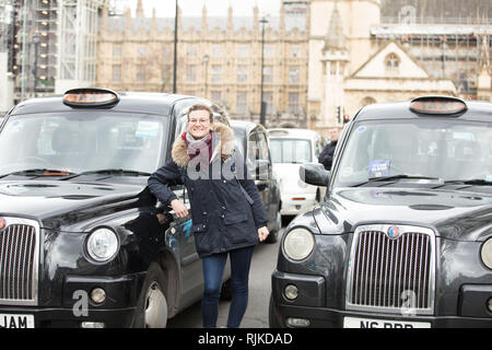 London, Großbritannien. Februar 2019. Touristen, die während des Londoner Taxifahrens auf dem Parliament Square ein Foto machen. Kredit: Joe Kuis / Alamy Live Nachrichten Stockfoto