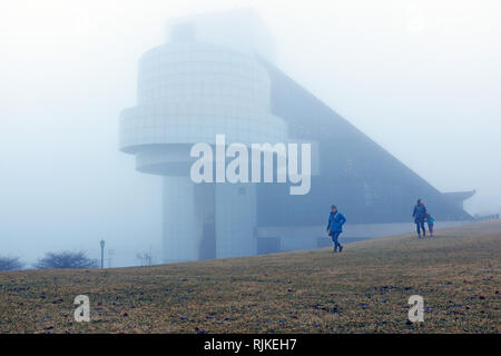 Cleveland, Ohio, USA. 6 Feb, 2019. Drei Frauen gehen weg von der Rock and Roll Hall of Fame und Museum entlang der Nebel - North Coast Harbor. Wild Schaukeln in Wetter, Regen, Nebel, Schnee, Schneeregen oder Regen auf die in der vergangenen Woche. Credit: Mark Kanning/Alamy Leben Nachrichten. Stockfoto