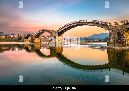 Iwakuni, Yamaguchi, Japan in der Kintaikyo Brücke über den Nishiki Fluss in der Dämmerung. Stockfoto