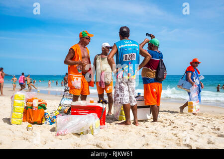 RIO DE JANEIRO - Februar, 2016: eine Gruppe brasilianischer Strandverkäufer stehen zusammen auf dem Ufer von Ipanema Beach, eine Pause vom Wandern in Hitze. Stockfoto