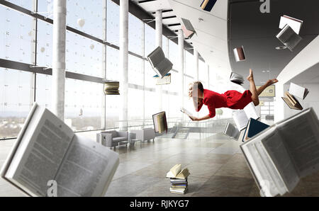 Entspannt Frau levitates in Raum voller Fliegen Bücher. Mixed Media Stockfoto