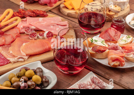 Gourmet Wurstwaren. Eine Auswahl an Wurst und Schinken, Aufschnitt, und eine Käseplatte mit Wein und Oliven Stockfoto