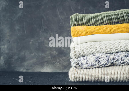 Stapel aus Gewirken aus Wolle pullover Herbst Farben. Kleidung mit verschiedenen Strickmuster im Stapel gefaltet. Warmen gemütlichen Winter fallen Strickwaren Konzept. Kopieren Stockfoto