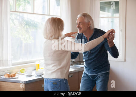 Liebevolle senior Paar, Mann und Frau tanzen in der Küche Stockfoto