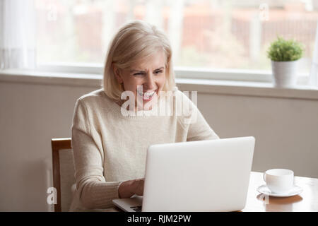 Freundliche ältere Frauen sitzen am Tisch die Wiedergabe von Videos auf dem PC Stockfoto