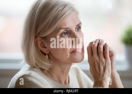 Portrait von traurige Frau cogitating alleine Zuhause sitzen Stockfoto