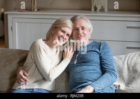 Wohlbefinden im Alter zwischen Ehegatten sitzen auf einem Sofa an Kamera suchen Stockfoto