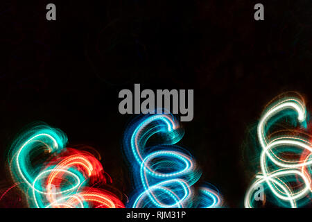 Close-up glühenden Federn auf schwarzem Hintergrund. Abstrakte Zeichnung. Fotografische Effekt mit langen Belichtungszeit. Stockfoto