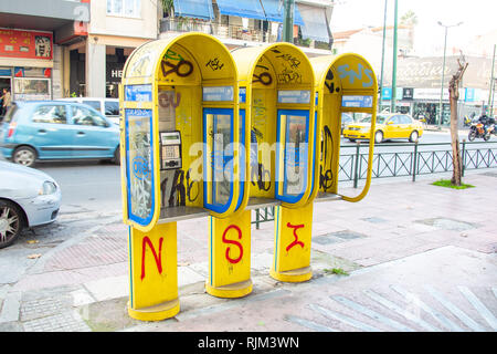 Drei öffentliche Telefone in Graffiti an einer Wohnstraße in Athen, Griechenland abgedeckt Stockfoto