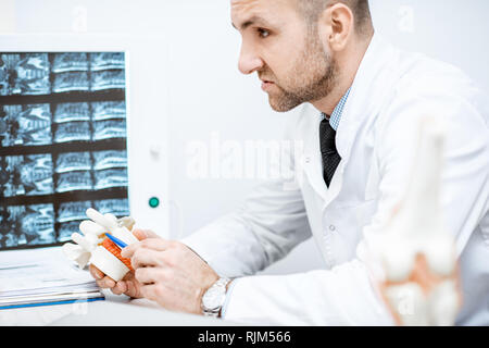 Therapeut Holding anatomische Modell der Wirbelkörper mit Bandscheiben Bandscheibenvorfall während der medizinische Beratung Stockfoto