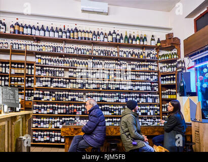 Turin, Italien - 31. Dezember 2018. Kunden vor einem Wein Flaschen Wand eines italienischen Weinbar. Turin, Piemont, Italien. Stockfoto