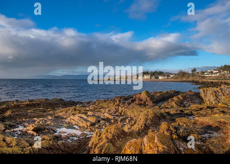 Die Stadt von Largs auf den Firth of Clyde an der Westküste von Schottland. Über Flechten bedeckte Felsen über die Bucht auf die Stadt. Stockfoto