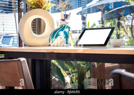 Digitale Tablette mit leeren Bildschirm auf hölzernen Tisch in Coffee Shop. Stockfoto