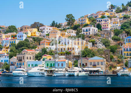 Segelboote, Yachten und bunten Häuser in der Hafenstadt Symi (Insel Symi, Griechenland) Stockfoto