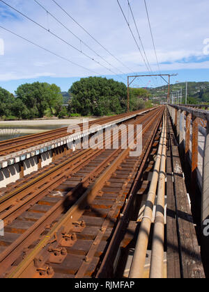 Blick auf rostigen Schienen, die über eine Eisenbahnbrücke Stockfoto