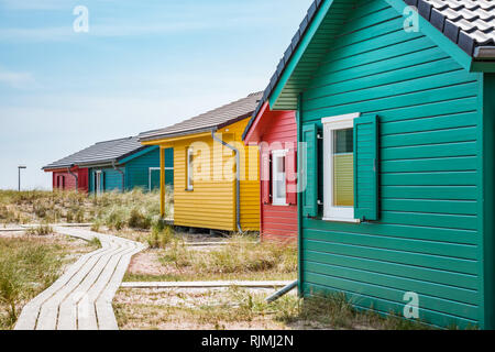 Bunte Holzhäuser mit Fensterläden am Strand Stockfoto
