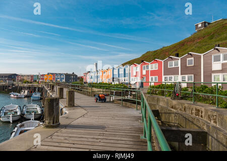 Sun am Hafen von Helgoland mit bunten Holzhäusern Stockfoto