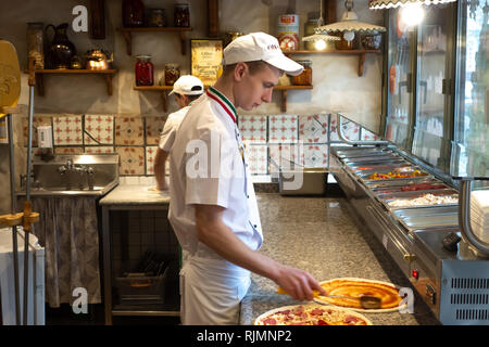 Mann Vorbereitung Teig für Pizza auf dem Holztisch, close-up Stockfoto