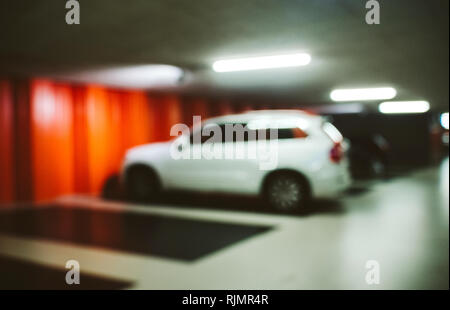 Defokussierten Schuß von beleuchteten unterirdischen Parkplatz mit SUV-Auto auf lose Stockfoto