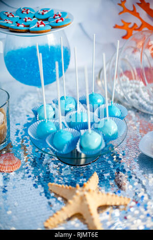 Blauer Kuchen knallt auf den silbernen Tuch. Meer Zeit Thema auf Candy Bar der Partei. Stockfoto