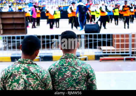 Kuala Lumpur, Malaysia. August 22, 2017. Zwei malaysischen Armee Männer beobachten Malaysischen teens Praxis für die nationalen Tag 60th Jahrestag Feier ich Stockfoto