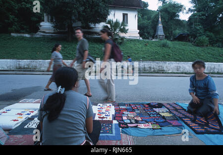 Hmong Bergvolk Frauen ihr Handwerk waren Verkauf zu einem behelfsmäßigen Markt in Luang Prabang. Experten in Kreuzstich und Quilten, die jüngsten Boom in Stockfoto