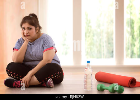 Deprimiert übergewichtige Frau sitzt auf dem Boden und nicht die Gewohnheit, Übung Stockfoto