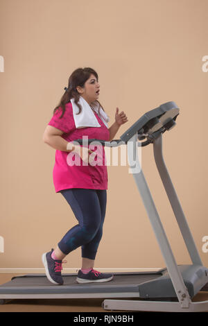 Fette Frau tun Übung auf Laufband im Fitnessstudio Stockfoto